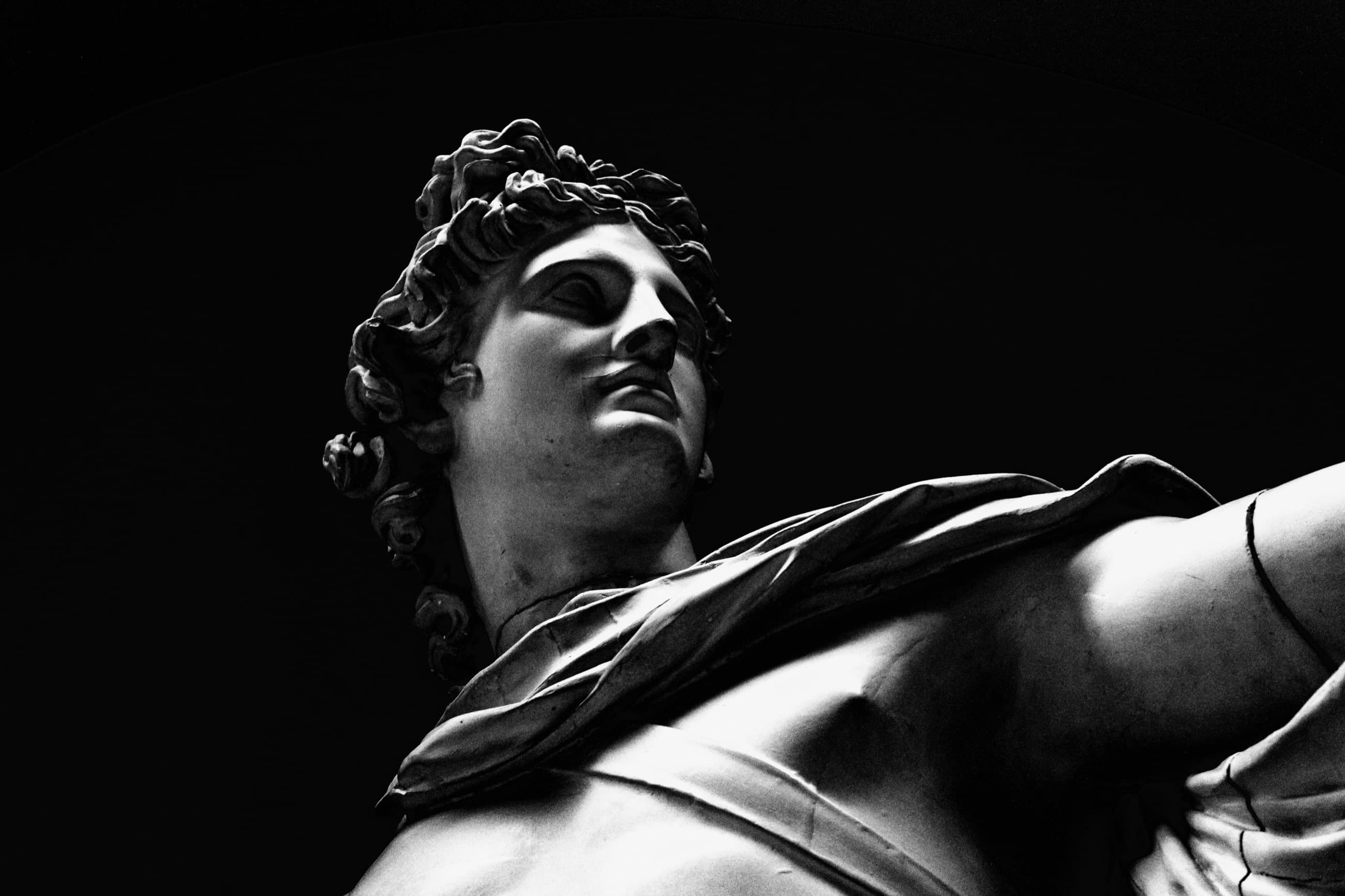 A marble statue lit against black